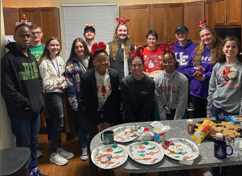 Photo of University of Evansville students dressed in christmas sweaters at party for UE Faith in Action